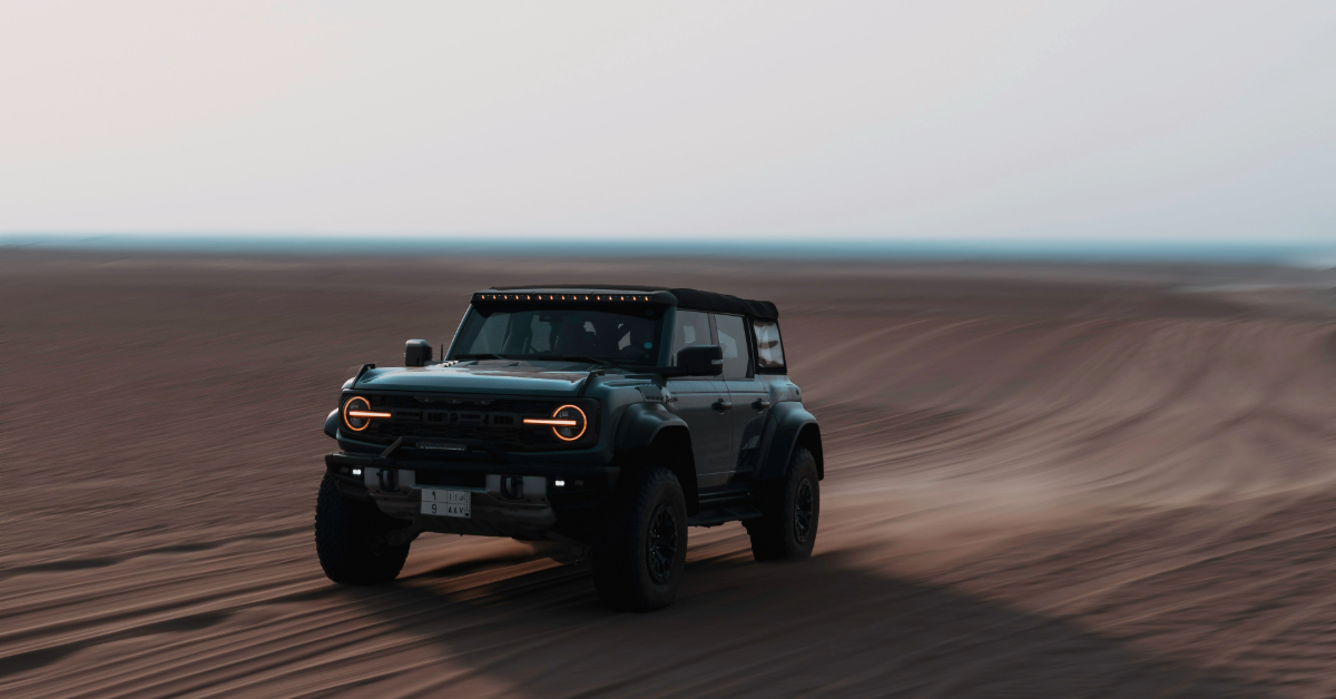 A Ford Bronco going full speed in the desert.
