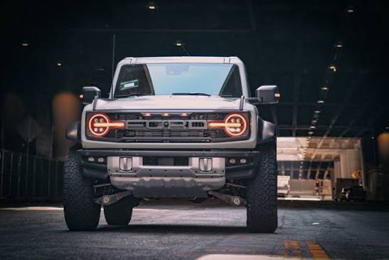 Front picture of a Ford Bronco with headlights on