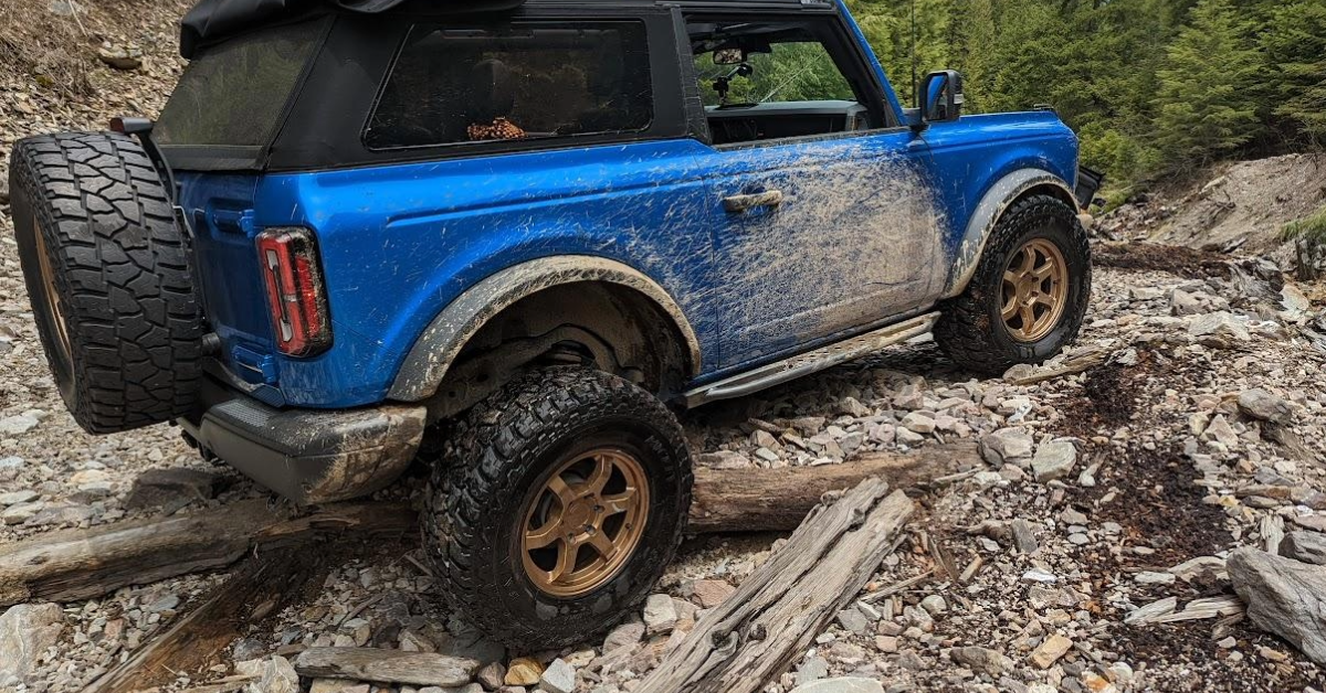 Dirty Ford Bronco showing side view with rock rails visible
