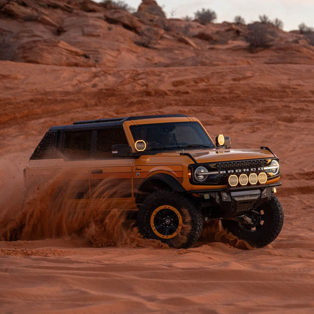 DV8 Offroad FBBR-08 Tube Series front bumper installed on dark Ford Bronco – red rock trail Moab
