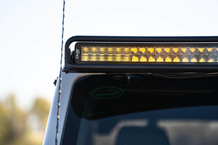 DV8 Offroad 52-inch straight light bar mount installed on 2021-2026 Ford Bronco close-up of amber LED bar above windshield