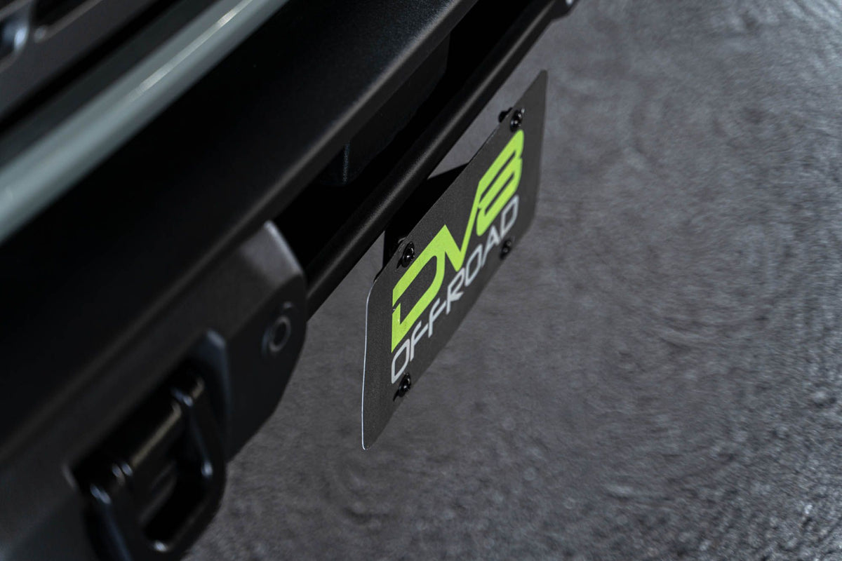 DV8 Offroad license plate mount installed on 2021-2026 Ford Bronco close-up showing DV8 Offroad branding on bracket