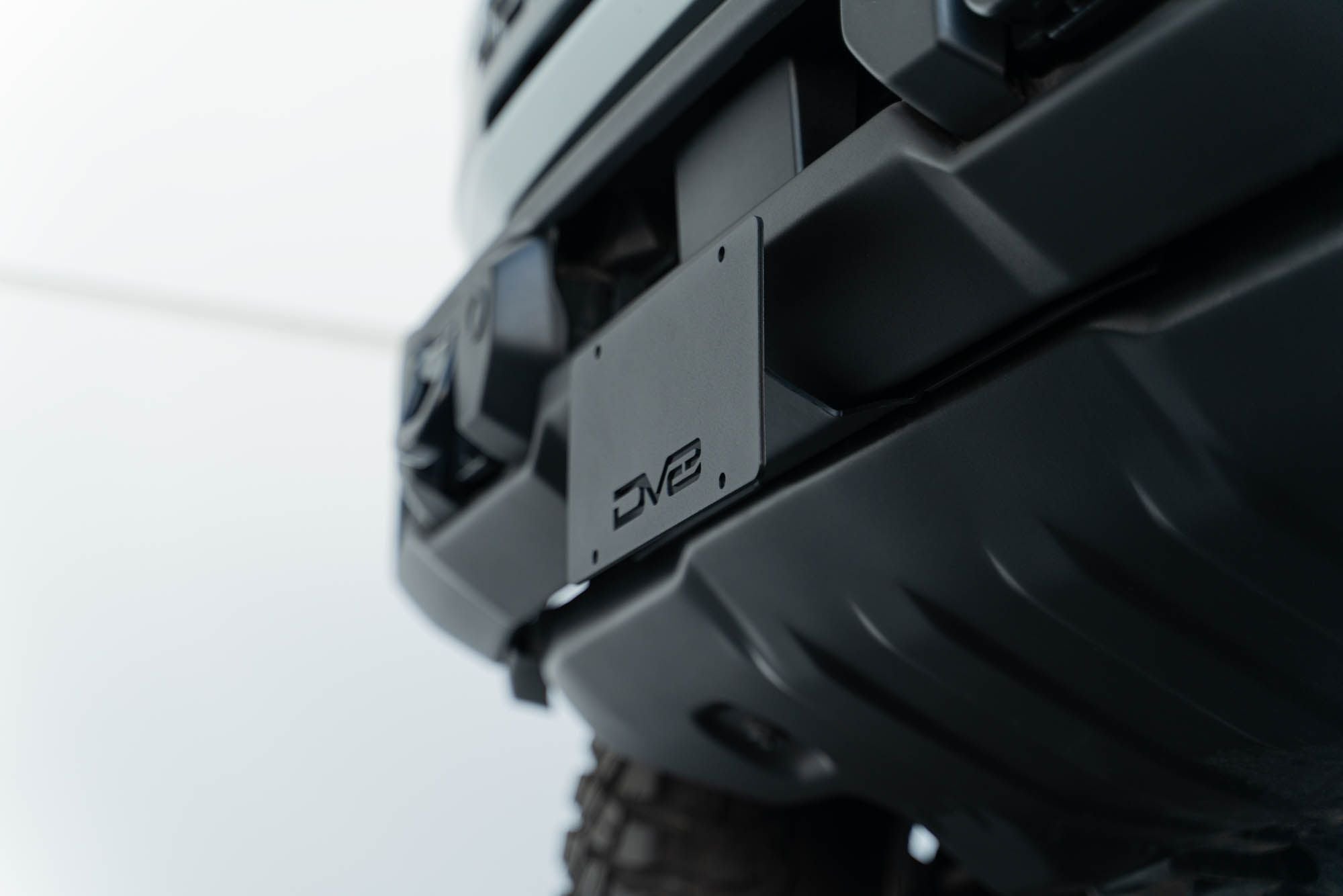 DV8 Offroad license plate mount installed on 2021-2026 Ford Bronco side view showing bracket position on Capable bumper