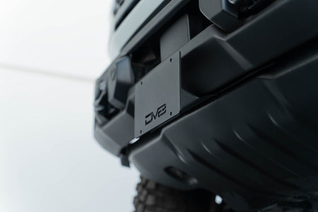 DV8 Offroad license plate mount installed on 2021-2026 Ford Bronco side view showing bracket position on Capable bumper