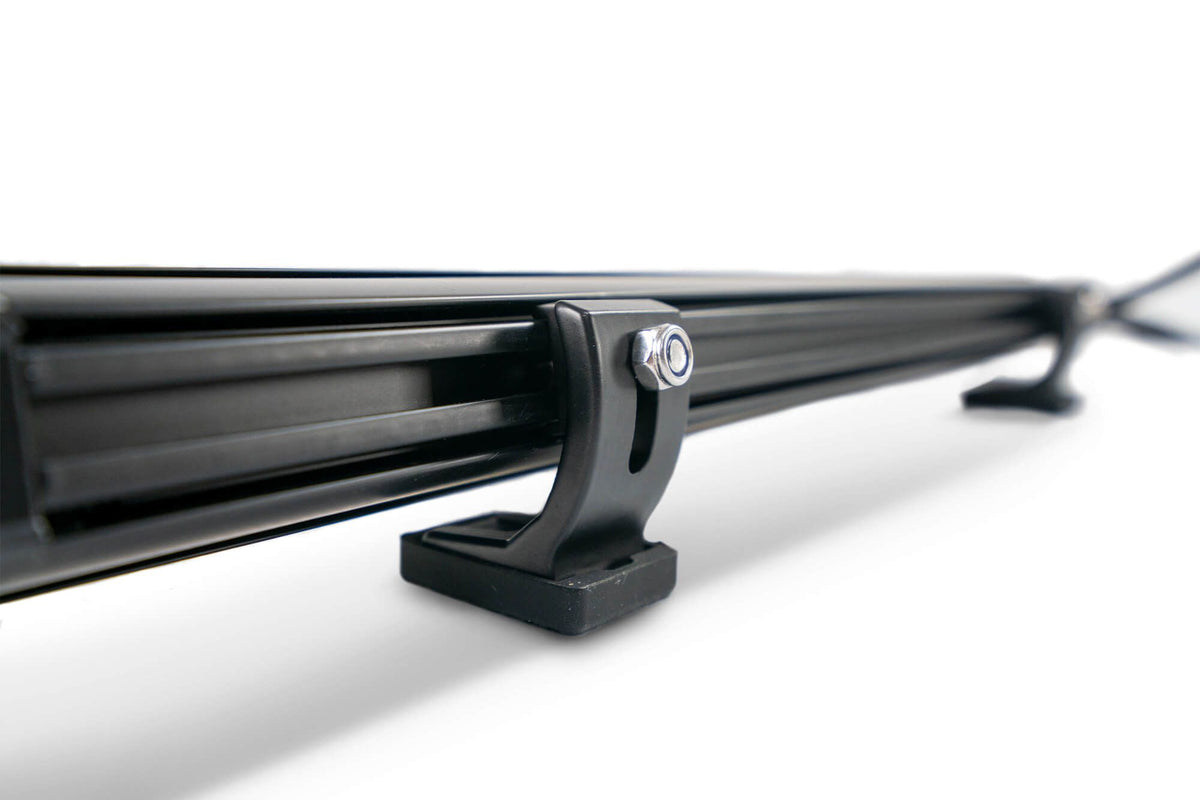 DV8 Offroad small elite series LED light bar mount close-up product shot showing rubber feet and rear slide adjustment mechanism