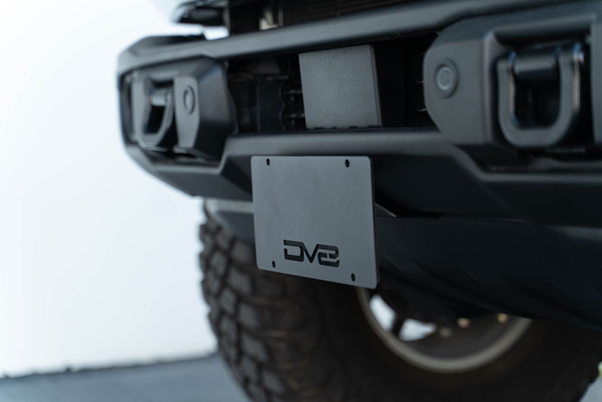 DV8 Offroad license plate mount installed on 2021-2026 Ford Bronco Capable bumper side corner close-up view