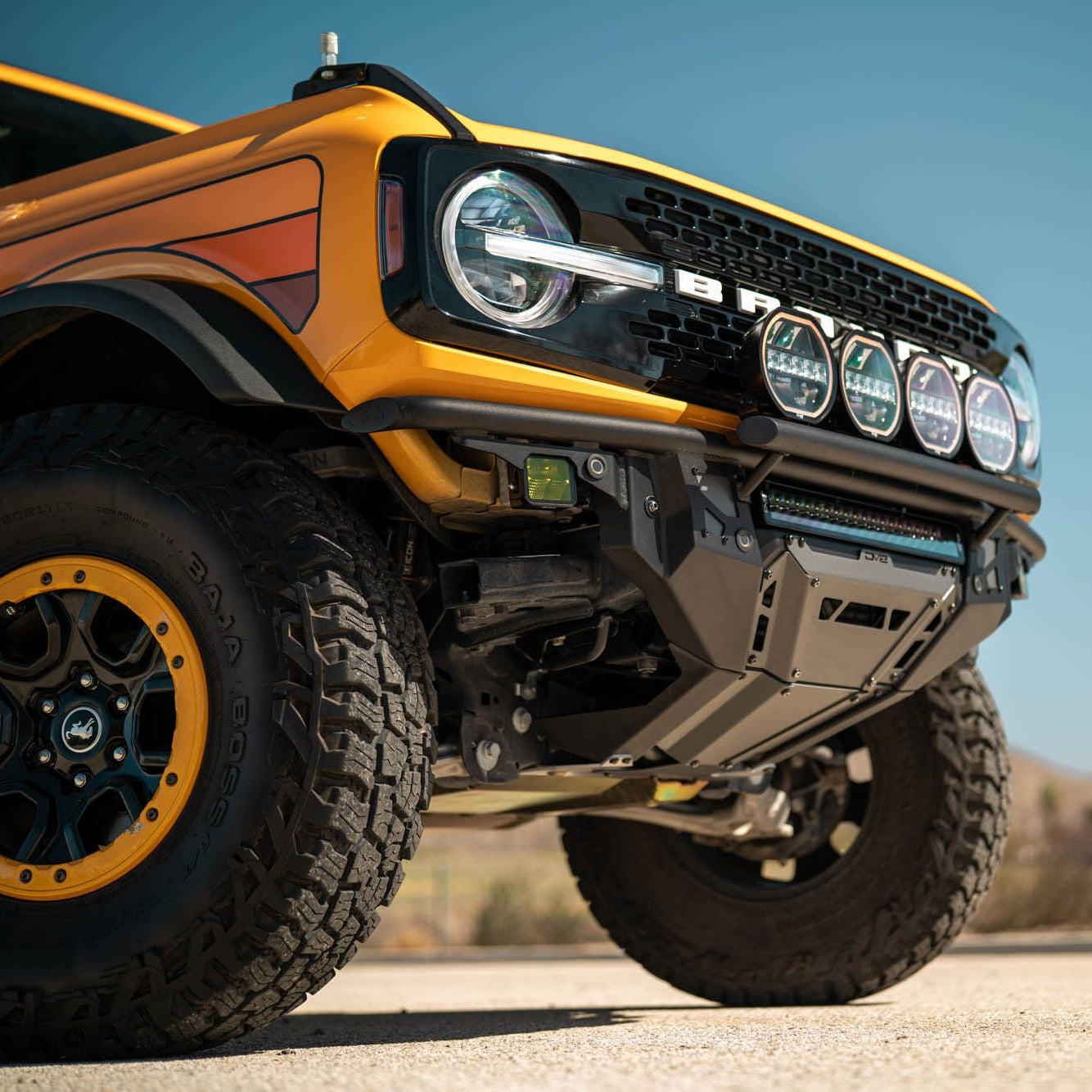 DV8 Offroad FBBR-08 Tube Series front bumper installed on yellow Ford Bronco – low angle desert shot