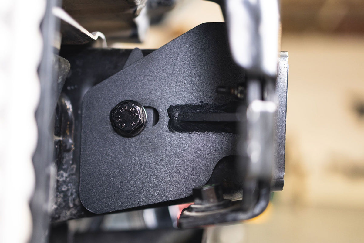 DV8 Offroad frame horn reinforcement bracket installed on Ford Bronco frame, close-up showing mounting bolt