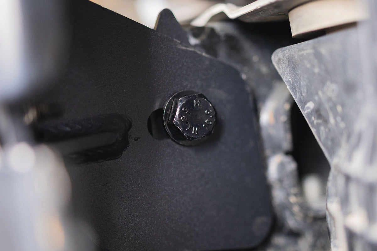 DV8 Offroad frame horn reinforcement bracket installed on Ford Bronco frame, close-up showing hex bolt