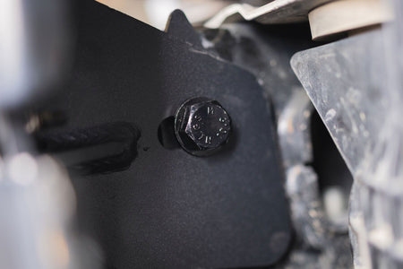 DV8 Offroad frame horn reinforcement bracket installed on Ford Bronco frame, close-up showing hex bolt