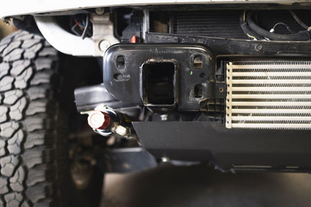 DV8 Offroad frame horn reinforcement bracket installed on Ford Bronco, undercarriage view showing intercooler and frame