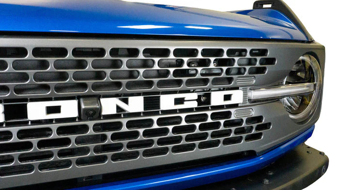 Close-up of a blue Bronco's grille with Bronco logo showing
