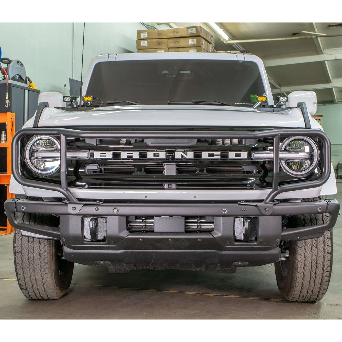Turn Offroad modular bumper grille guard installed on white Ford Bronco, front three-quarter view in warehouse setting