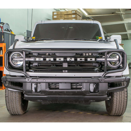 Turn Offroad modular bumper grille guard installed on white Ford Bronco, front three-quarter view in warehouse setting