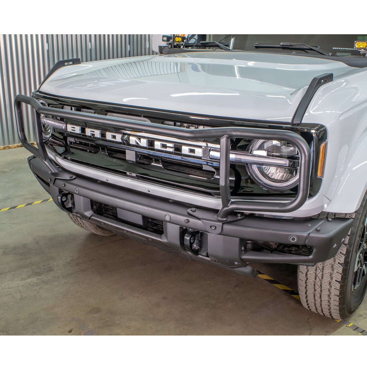 Turn Offroad modular bumper grille guard installed on white Ford Bronco, straight-on close-up in shop setting