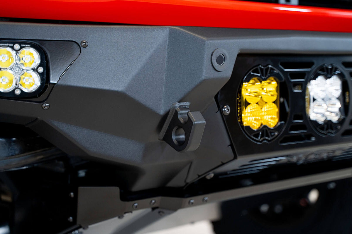 Addictive Desert Designs Bomber Baja front bumper close-up showing amber and white light pods on bumper corner