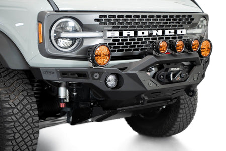 Addictive Desert Designs Krawler front bumper installed on gray Ford Bronco with amber marker lights, front three-quarter close-up view, second angle
