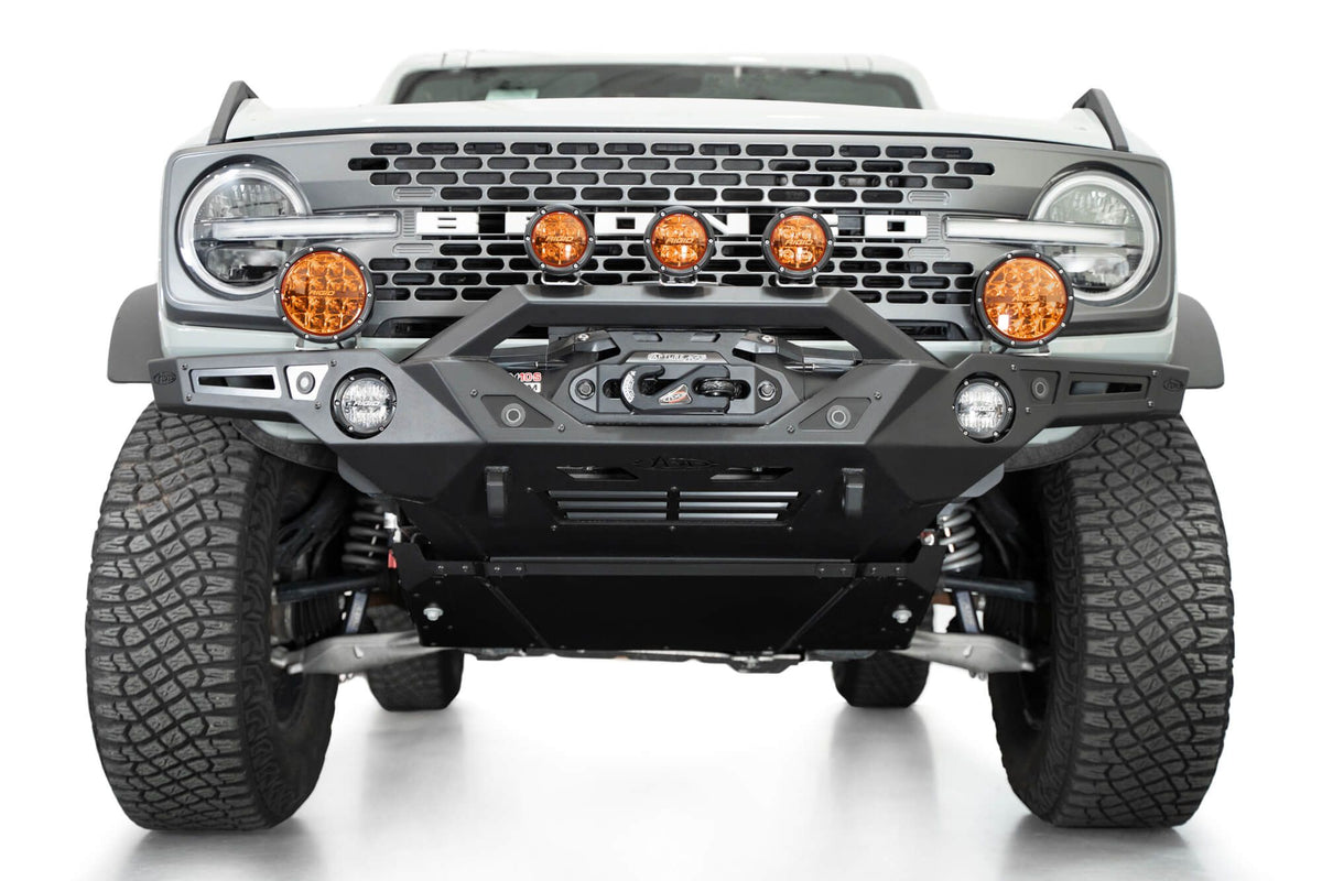 Addictive Desert Designs Krawler front bumper installed on gray Ford Bronco with amber marker lights, front three-quarter close-up view, third angle