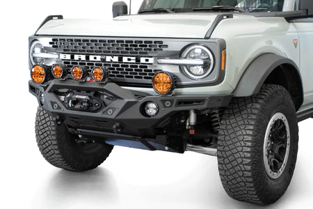 Addictive Desert Designs Krawler front bumper installed on gray Ford Bronco with amber marker lights, front three-quarter close-up view, alternate angle