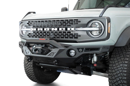 Addictive Desert Designs Krawler front bumper installed on gray Ford Bronco with amber marker lights, front three-quarter close-up view