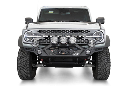 Addictive Desert Designs Krawler front bumper installed on gray Ford Bronco with amber marker lights, straight-on front view of full vehicle, product shot on white background