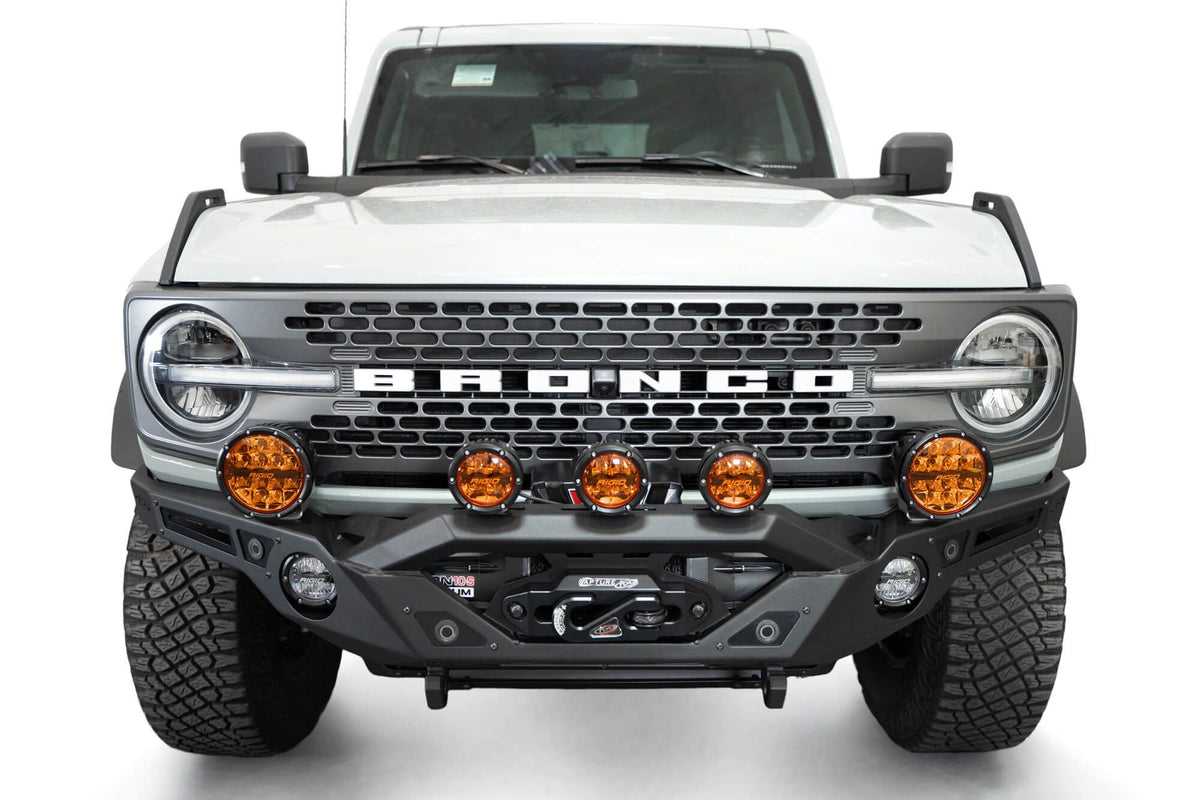 Addictive Desert Designs Krawler front bumper installed on gray Ford Bronco with amber marker lights, straight-on close-up view