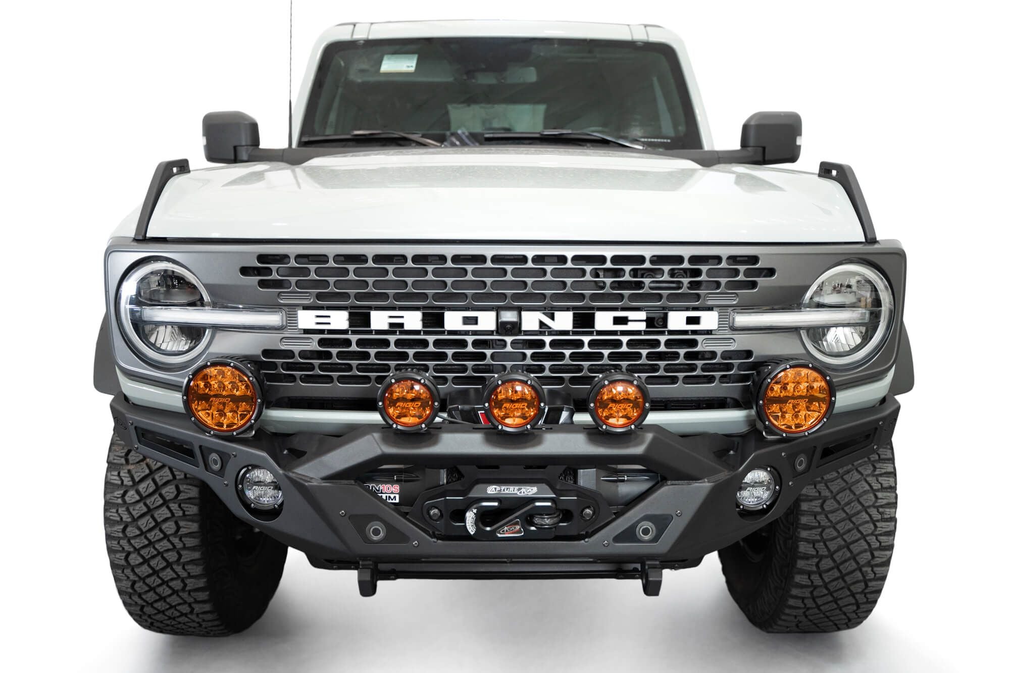 Addictive Desert Designs Krawler front bumper installed on gray Ford Bronco with amber marker lights, straight-on close-up view