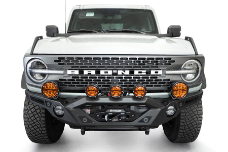 Addictive Desert Designs Krawler front bumper installed on gray Ford Bronco with amber marker lights, straight-on close-up view