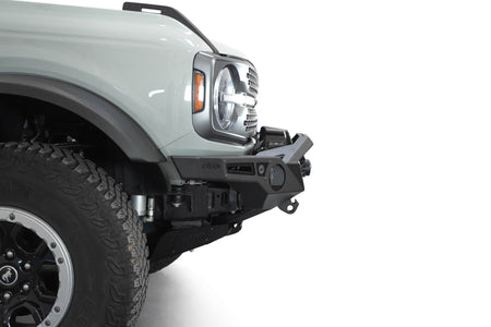 Addictive Desert Designs Krawler front bumper installed on gray Ford Bronco, close-up showing fender, headlight, and bumper corner