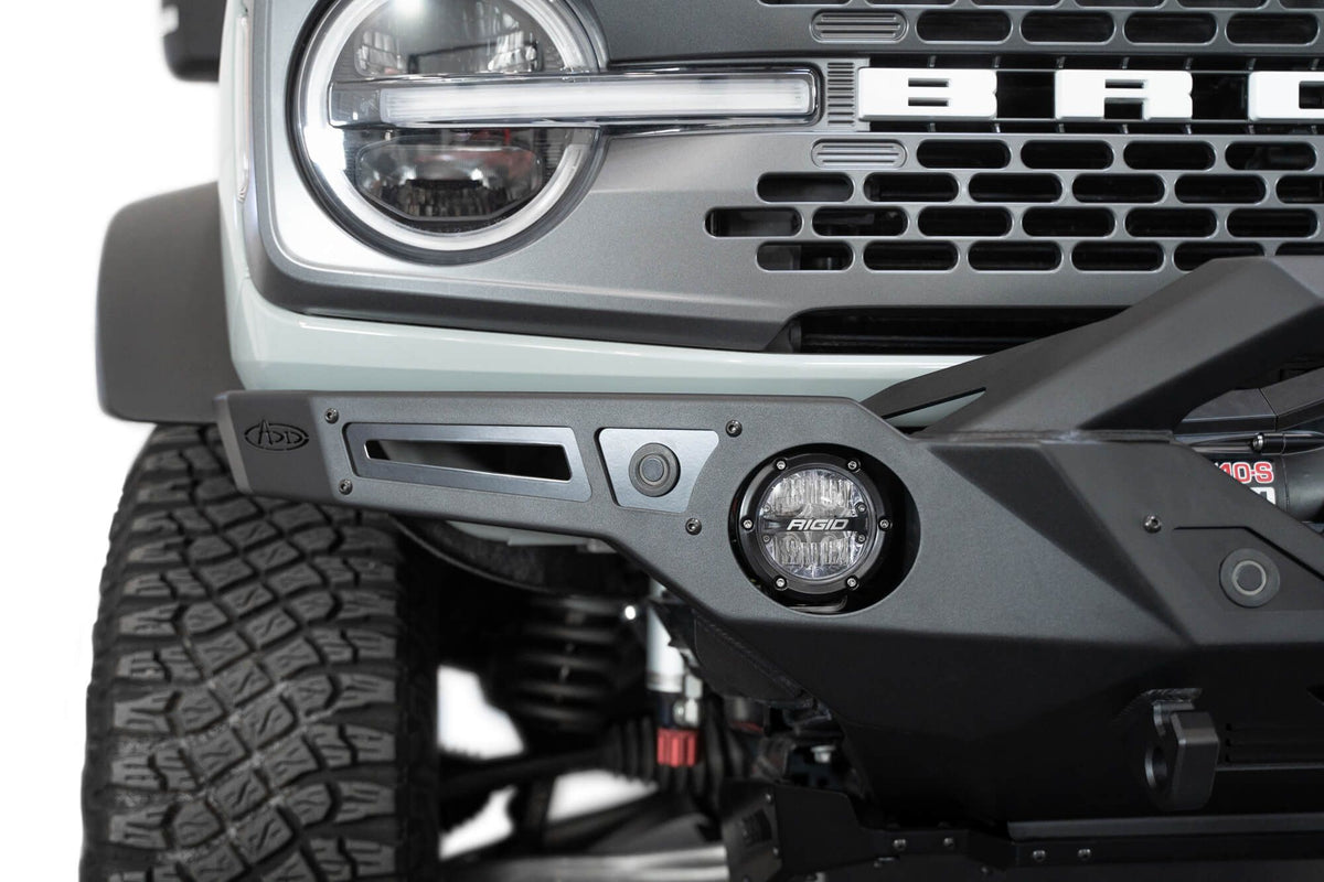 Addictive Desert Designs Krawler front bumper installed on gray Ford Bronco, close-up showing grille and bumper