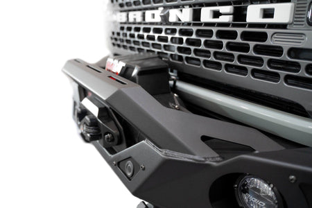 Addictive Desert Designs Krawler front bumper installed on gray Ford Bronco, close-up showing grille and bumper top edge