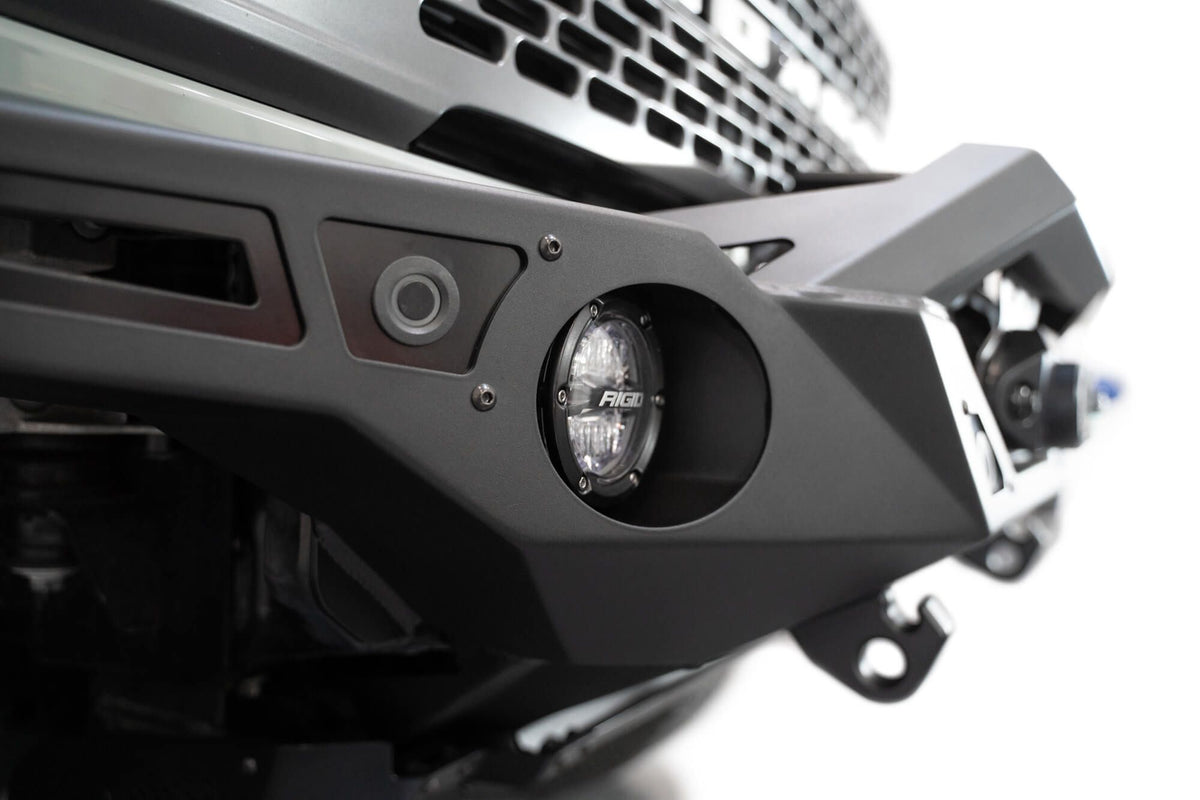 Addictive Desert Designs Krawler front bumper installed on gray Ford Bronco, close-up showing round headlight and bumper corner