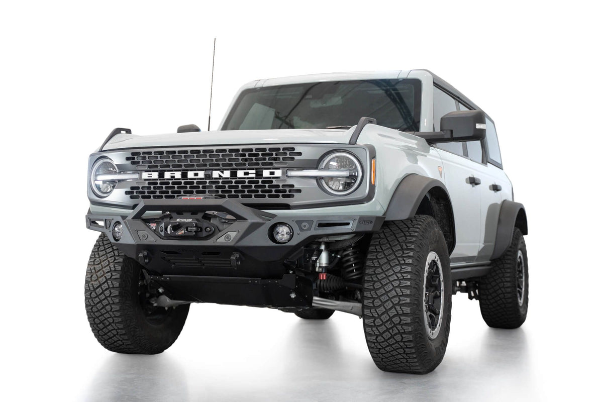 Addictive Desert Designs Krawler front bumper installed on gray Ford Bronco, front three-quarter view product shot on white background, alternate angle