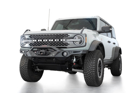 Addictive Desert Designs Krawler front bumper installed on gray Ford Bronco, front three-quarter view product shot on white background, alternate angle