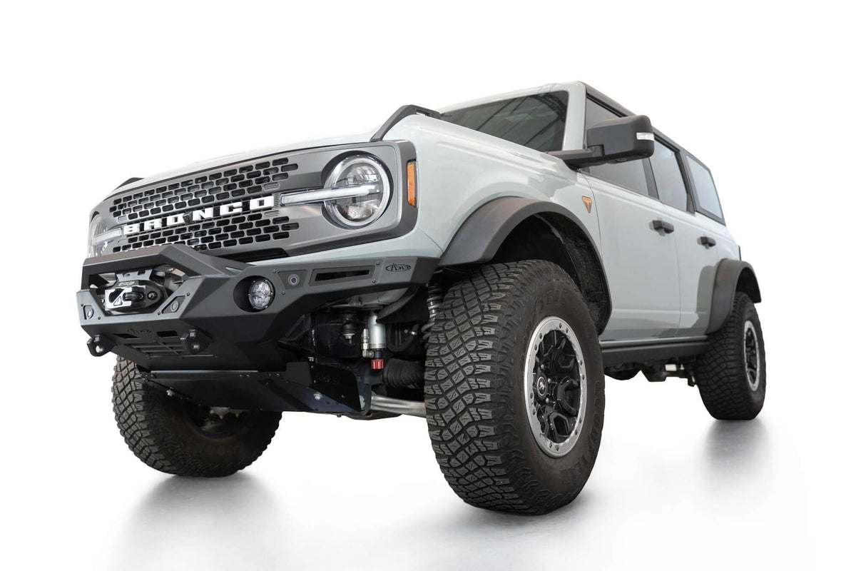 Addictive Desert Designs Krawler front bumper installed on gray Ford Bronco, front three-quarter view of full vehicle, product shot on white background, alternate angle
