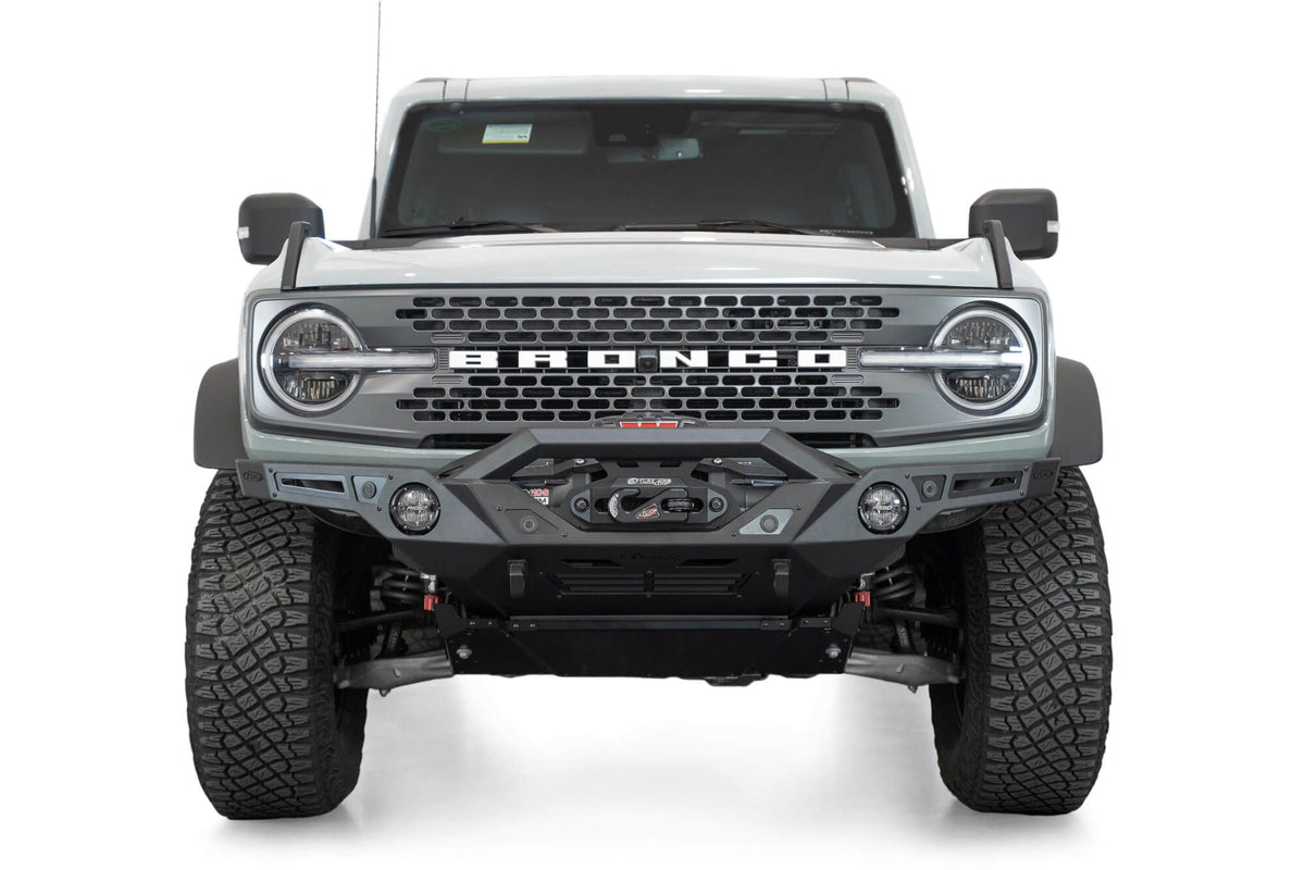 Addictive Desert Designs Krawler front bumper installed on gray Ford Bronco, straight-on front view product shot on white background