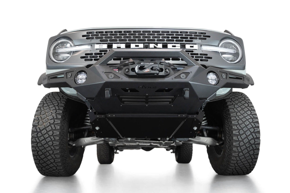 Addictive Desert Designs Krawler front bumper installed on Ford Bronco, underside close-up showing skid plate, straight-on view