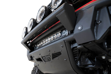 Addictive Desert Designs PRO Bolt-On front bumper installed on red Ford Bronco, angled close-up showing bumper corner and light bar mount