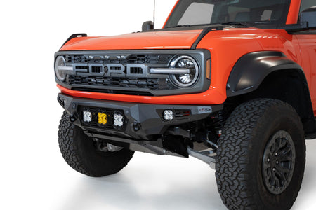 Addictive Desert Designs Bomber Baja front bumper installed on Ford Bronco Raptor, close-up showing headlight and bumper corner detail