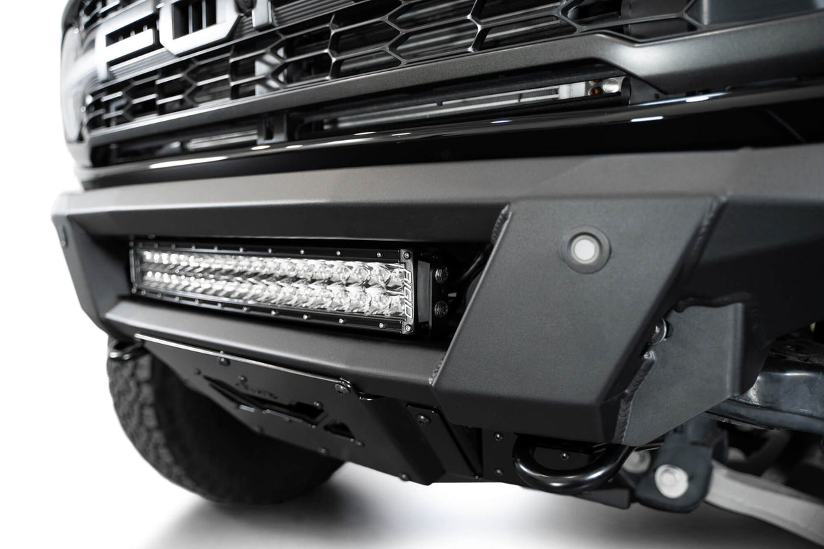 Addictive Desert Designs Phantom front bumper installed on black Ford Bronco Raptor, straight-on close-up showing full light bar width