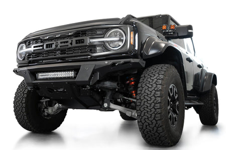 Addictive Desert Designs Phantom front bumper installed on black Ford Bronco Raptor, close-up front three-quarter view showing grille and bumper, product shot on white background