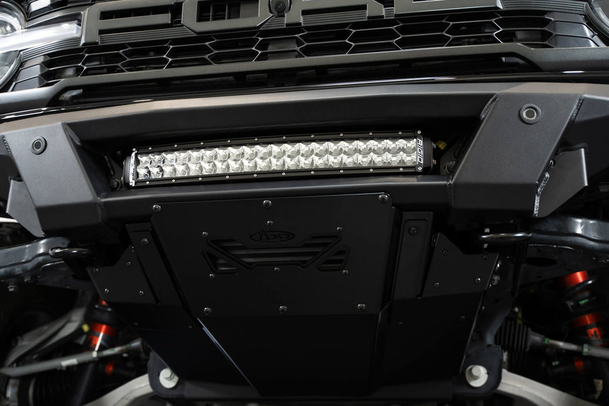 Addictive Desert Designs Phantom front bumper installed on black Ford Bronco Raptor, straight-on close-up showing light bar and bumper center