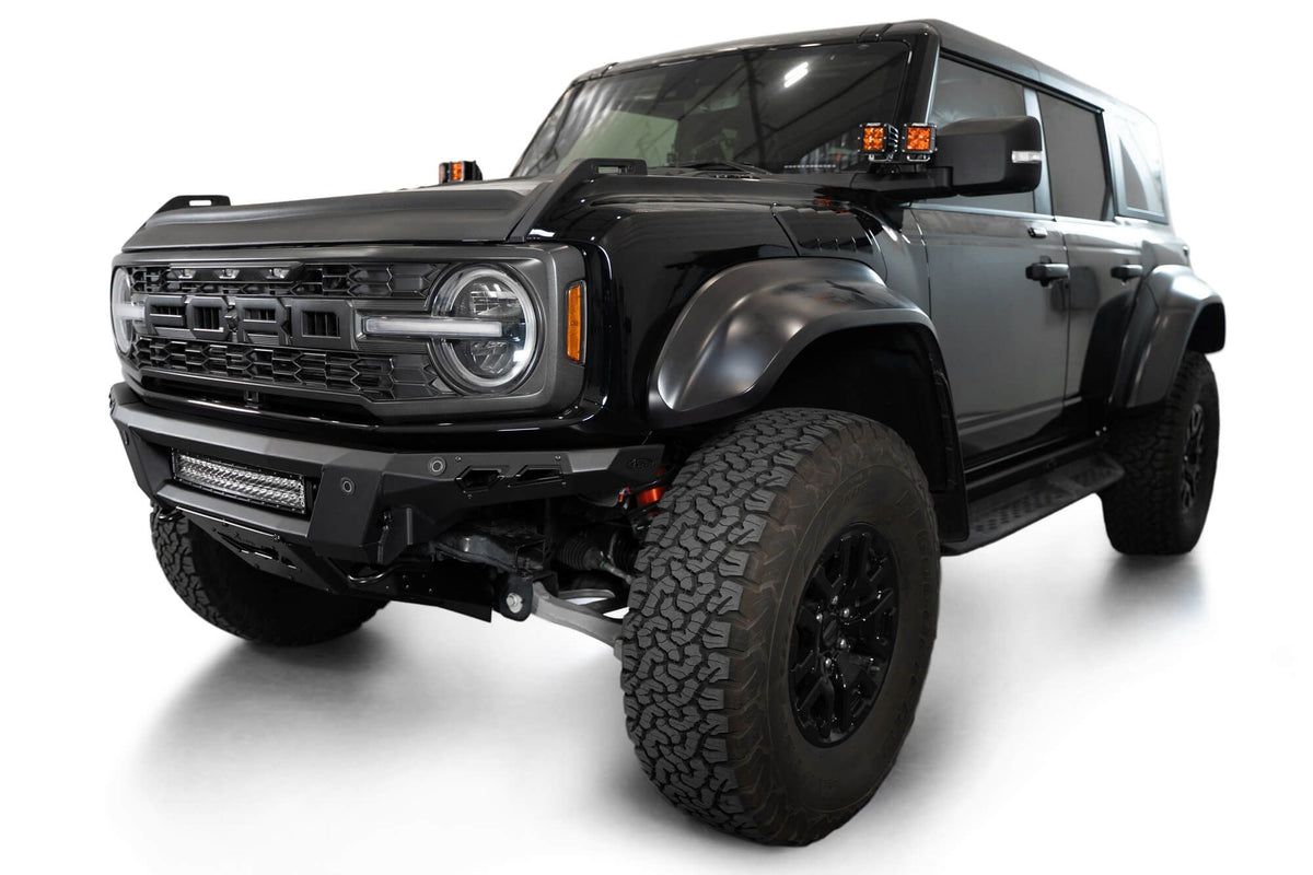 Addictive Desert Designs Phantom front bumper installed on black Ford Bronco Raptor, front three-quarter view of full vehicle with marker lights, product shot on white background