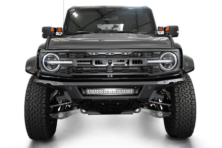 Addictive Desert Designs Phantom front bumper installed on black Ford Bronco Raptor, straight-on front view with roof rack, product shot on white background