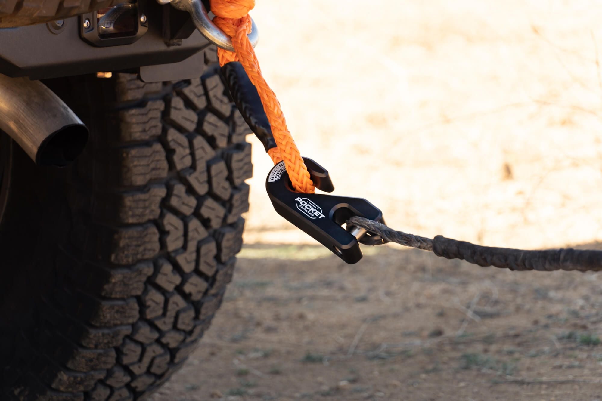 A pocket fairlead hooked around an orange rope 