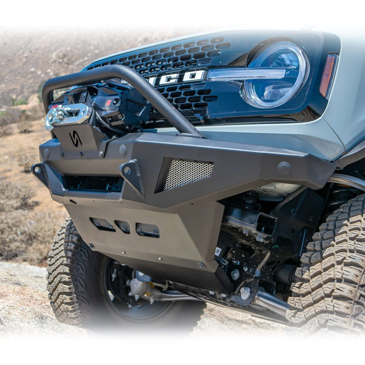 Turn Offroad winch front bumper package installed on Ford Bronco, front three-quarter close-up view on rocky terrain