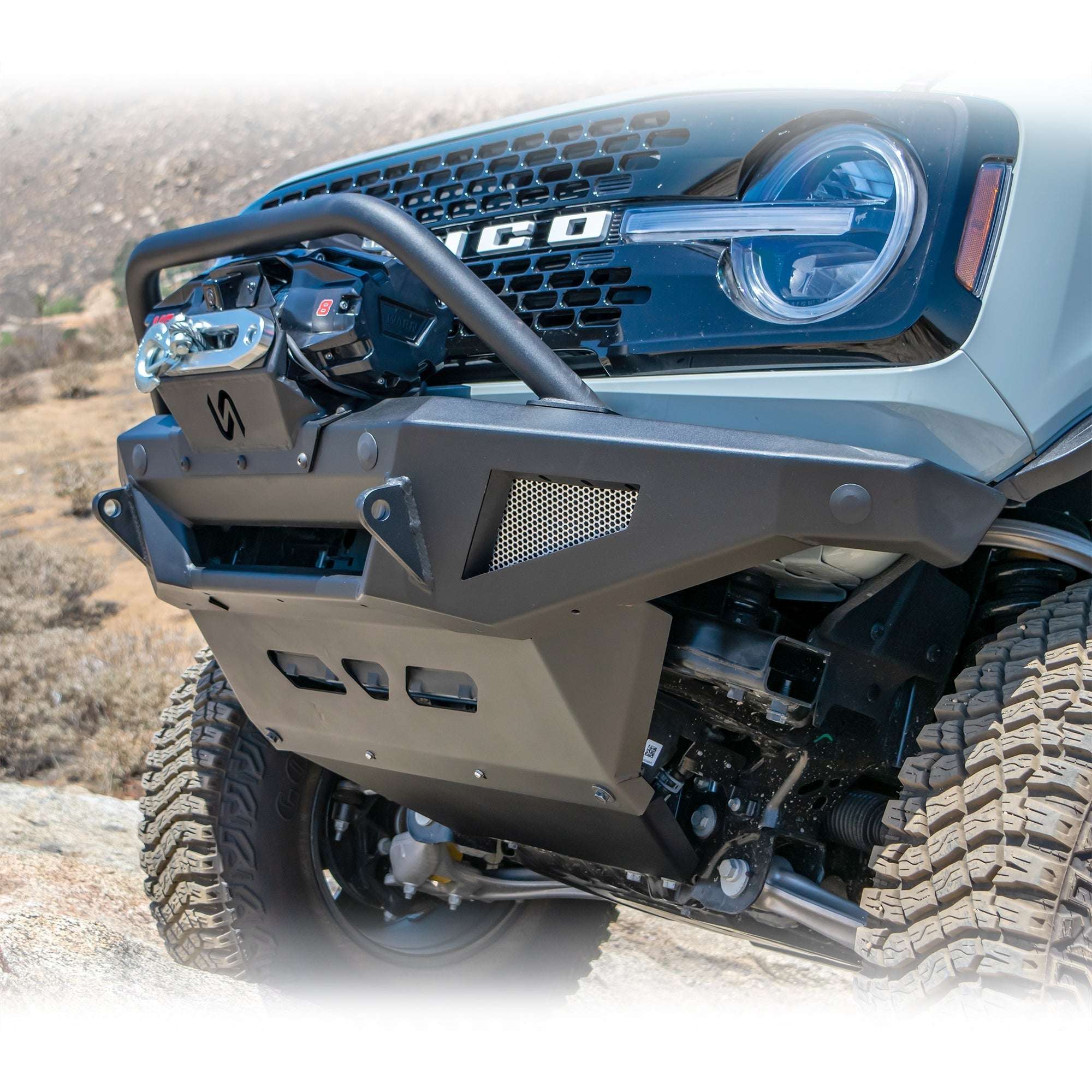 Turn Offroad winch front bumper package installed on Ford Bronco, front three-quarter close-up view on rocky terrain