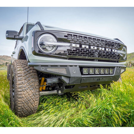 Turn Offroad Baja front bumper and skid plate installed on gray Ford Bronco, front three-quarter close-up view in grass field