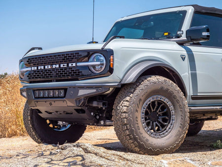 Turn Offroad Baja front bumper and skid plate installed on gray Ford Bronco, front three-quarter view on rocky terrain, alternate angle
