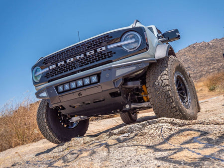 Turn Offroad Baja front bumper and skid plate installed on gray Ford Bronco, front three-quarter view on rocky terrain